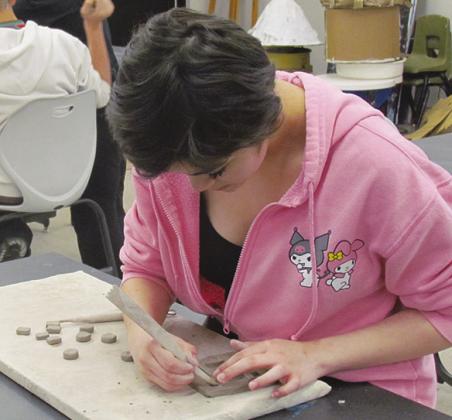 Kiki Salas cuts out pieces of clay for her own tic-tac-toe board at Clinton Middle School.