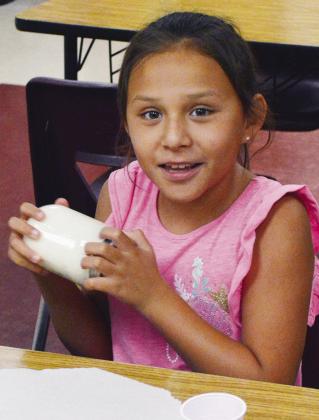 Kyiah Lime shakes the jar of milk as fast as she can to help make it into butter Wednesday during the Discovery Zone class at Washington Elementary. CDN | Christian Jacobsen