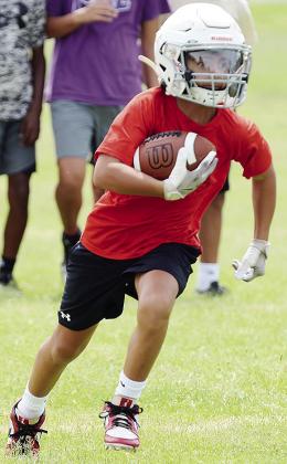 BentLee Potter carries the ball during the first day of football practice for the Whirlwinds Monday at Clinton Middle School. CDN | Sam Goodwyn