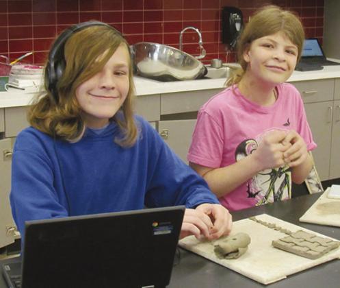 Justin Schenewolf, left and Kayla Nitche mold clay into a tictac-toe board and pieces. CDN | Christian Jacobsen