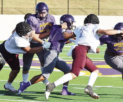 Clinton’s Alex Amaya, left, and Easten Powell fight through blocks as they try to take down the ball carrier during the Red Tornadoes scrimmage Friday in Anadarko. CDN | Sam Goodwyn