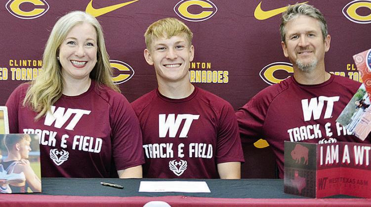 Clinton Red Tornadoes’ track and field athlete Parker Adams, center, is all smiles after signing to compete for the West Texas A&amp;M Buffaloes. He celebrates the signing with his mother Erin, left, and father Luke, right, by his side. CDN | Sam Goodwy