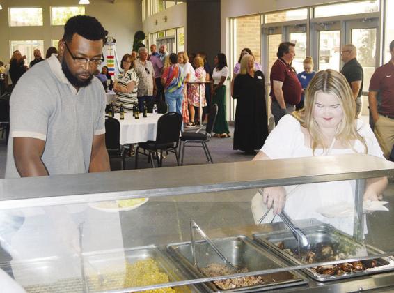 New teachers JR Powell, left, and Karley Graybill grab a plate of food at the recent New Teacher Luncheon at the Frisco Center. CDN | Christian Jacobsen