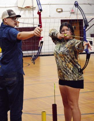 CDN | Micah Ashcraft Clinton High School archers Evan Hunter, left, and Alexis Vela take aim after tuning and breaking in their newest bows Tuesday afternoon ahead of their first practice.