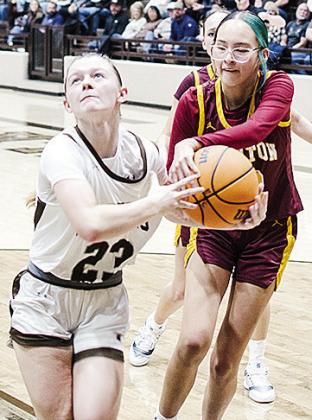 Clinton’s Rihanna Ellis, right, grabs onto the ball as the Elk City player attempts to drive past her Tuesday during the Lady Reds’ road game. CDN | Sam Goodwyn