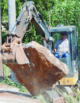 Gary Kluckner with the City of Clinton works to remove concrete from a collapsed drainage ditch Wednesday morning on Custer Avenue. CDN | Micah Ashcraft