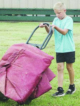 Lincoln Blundell manuevers the dolly full of tarps close to the fields Tuesday at Schumacher Fields at Acme Brick Park. CDN | Sam Goodwyn