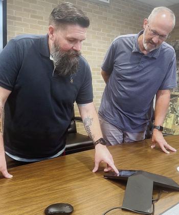 Brent Hester, left, and Gene McCullough examine an IT issue together while in the conference room at Clinton City Hall. CDN | Shiann Dawson