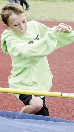 Wyatt Bailey leaps over the bar in the high jump event during Little Olympics. CDN |Sam Goodwyn
