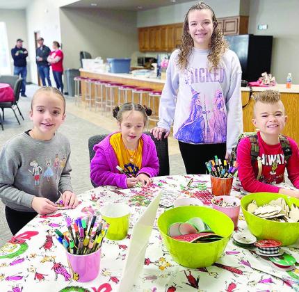 From left, Hazel Kauk, Claire Kreizenbeck, Audrey Kauk, and Maverick Kauk make Christmas-themed crafts during the annual Custer County 4-H Santa’s Workshop. CDN | Courtesy photo