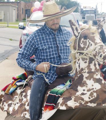 Alan Torres rides what appears at first glance a horse. The “horse” is powered by human legs underneath where Torres is “sitting.” CDN | Michael Maresh