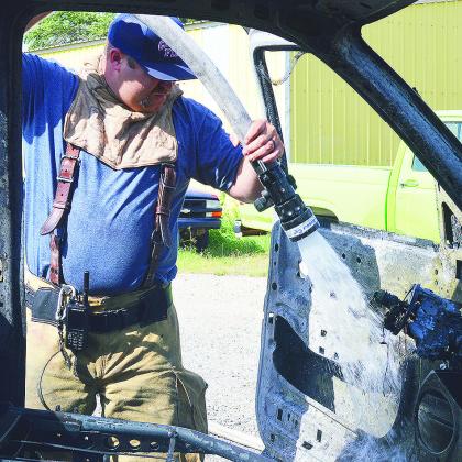 Lt. Jo Williams hoses the interior remains of a truck fire after the Clinton Fire Department responded Tuesday afternoon in the 200 block of Petty Lane. CDN | Micah Ashcraft