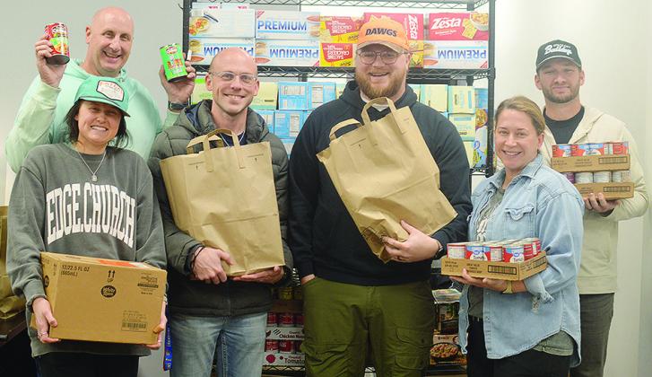 Edge Church members, front left, Tobi Green, Dane Krause, Stetson Green, Ashley Freelove; back, Hal Penner, and Kevin Leedy get bags of food ready to be given away for the Edge Church Grocery Giveaway set to start at 8 a.m. Sunday. CDN | Micah Ashcraft