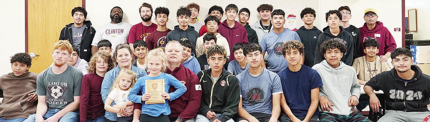 Clinton boys’ soccer coach Gene Ray celebrates with his family and team after being named the United Soccer Coaches 2024 State Coach of the Year for Oklahoma High School Boys Small Public Schools. Pictured in front, from left, are Miguel Hernandez, Trev