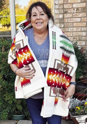 Cheyenne and Arapaho EMT Trauma Advisory Board Director Twila Ashcraft stands with her tribal blanket received after accepting the Moses Starr Jr. Honored Elders Award. CDN | Micah Ashcraft