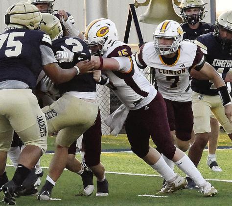Clinton’s No. 15 Gavin Evans pushes against the Kingfisher ball carrier as he tries to stop him with No. 7 Easten Powell coming to help during the Red Tornadoes’ road game Friday against the Yellowjackets. CDN | John Kinsey