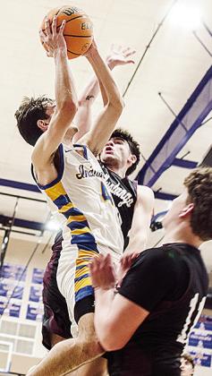 A-B’s Kaden Waldrop goes through two Pioneer-Pleasant Vale defenders for the layup during the Indians’ win Saturday over the Mustangs in the district championship game. CDN | Sam Goodwyn