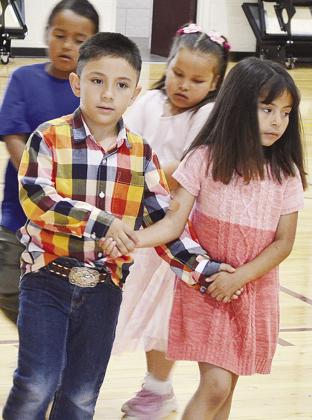 Leonardo Munoz Ramos, left, promenades with Emma Perez Coutino in front of Edson Ruiz and Lyla Pope during the kindergarten square dancing event Thursday at Nance Elementary to conclude the school year. CDN | Sam Goodwyn