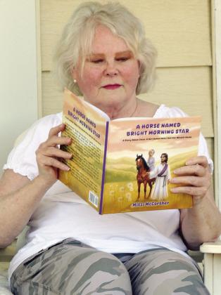 Mitzi McCarther reads her book “A Horse named Bright Morning Star” at her home in Clinton. CDN | Christian Jacobsen