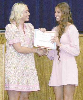 Kinley Grybowski, left, awards the Ashley Grybowski Memorial Scholarship to PiperRilee Sawatzky during the Senior Awards ceremony at the A-B auditorium. CDN | Courtesy photo