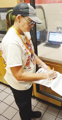Scarlett Scheib puts fries into a container for students’ lunches at Clinton Middle School. CDN | Sam Goodwyn