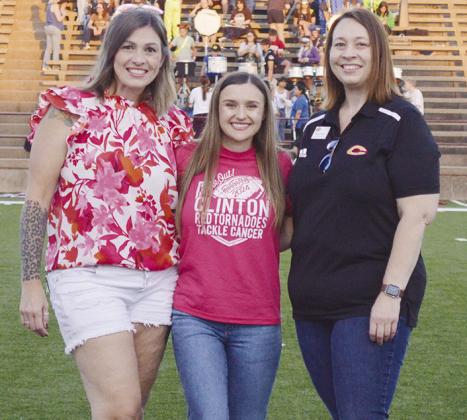 Clinton High School Principal Michelle Sorter, left, and Clinton Public Schools Asst. Supt. Melissa Knabe, right, recognize Clinton High School Teacher Jacklyn Olney as the Red Tornado Teacher of the Game before kickoff at last Friday’s game at the Torn