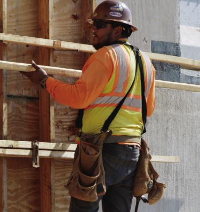 Victor Gonzalez locks in panels of wood to create the shape of the future Interstate 40 support beams at Red Wheat Drive. CDN | Christian Jacobsen