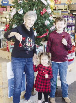 CDN | Sam Goodwyn Vi Drassen, left, and her two great grandchildren Vivian Baca, center, and Timber Hartman, left, smile as they ring the bells to help raise money during the holidays at Homeland.