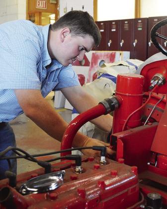 Ethan Hyers checks his students’ work on a tractor project at the Clinton High School Ag Shop. CDN | Micah Ashcraft