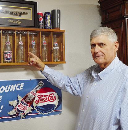 Clinton Chamber of Commerce Chair Mark Nicholson shows off his Pepsithemed glasses and memorabilia in his office at the Pepsi Bottling Group. CDN | Micah Ashcraft