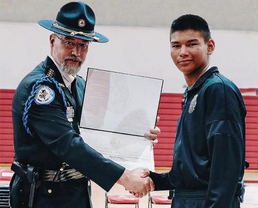 Deputy Director of the Bureau of Indian Affairs Glen Melville, left, presents soon to be Clinton High School freshman Nevin Hines his certificate for graduating through the Bureau of Indian Affairs’ Youth Police Academy program at the Riverside Indian S