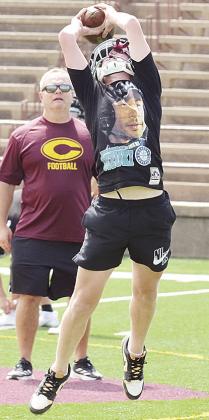 Freshman Axl Deatherage snags the ball with Assistant Coach Gene Ray watching during practice Monday. CDN | Sam Goodwyn