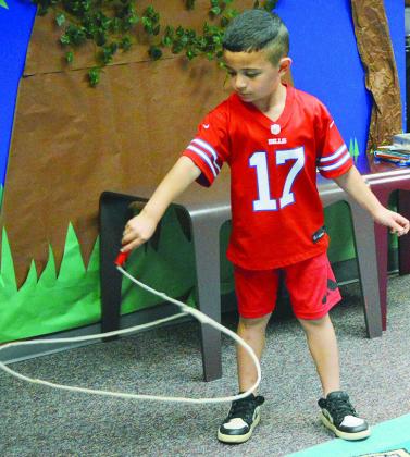 Sevy Acosta shows off how fast he can spin his lasso to his family at the Clinton Public Library. CDN | Christian Jacobsen