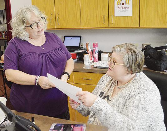 Patti Esparza, left, and Michelle Thompson check on school Tshirt orders while at the front desk at Washington Elementary School. CDN | Micah Ashcraft