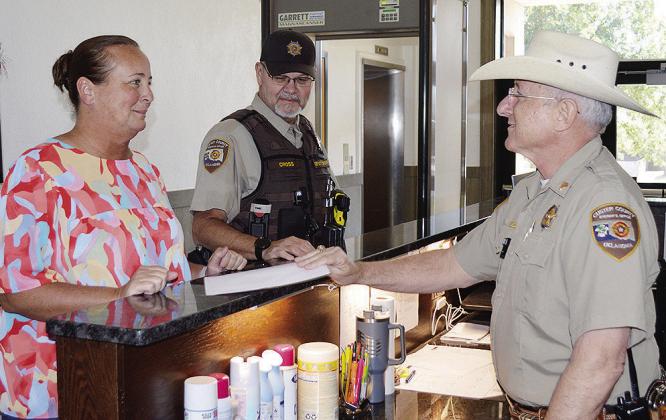From left, 1st Deputy Court Clerk Kyla Garibay, checks in with Lt. Kenneth Cross, and Sgt. Louis Flowers Thursday at the Custer County Courthouse in Arapaho. CDN | Christian Jacobsen