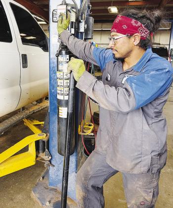 Roger Silva lifts a truck while at work at McKinsey Ford. CDN | Shiann Dawson