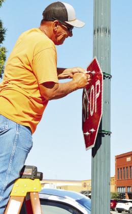 City of Clinton Streets Supervisor Craig Tucker replaces a fallen stop sign with a new one Wednesday morning at the corner of Sixth Street and Frisco Avenue. CDN | Micah Ashcraft