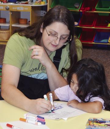 Miraonna, left, and Nayeli Cardenas are applying color to a “The Duckling Gets a Cookie” coloring page Tuesday at the Clinton Public Library. CDN | Christian Jacobsen