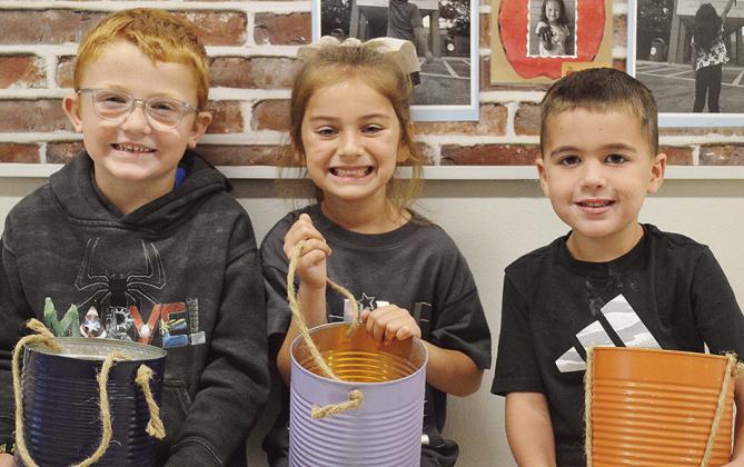 Arapaho-Butler kindergarteners, from left, Creek Dupree, Livi Salcido, and Carter Woodall show off their buckets that will be part of their booth setup for the Arapaho-Butler Carnival. CDN | Micah Ashcraft