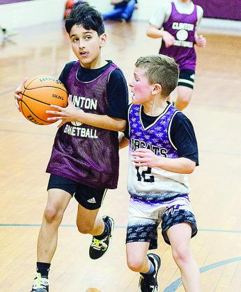 Sebastian Ringo, left, stares at the hoop as he drives down the lane during the fourth-grade boys’ basketball game against Hydro. CDN |Sam Goodwyn
