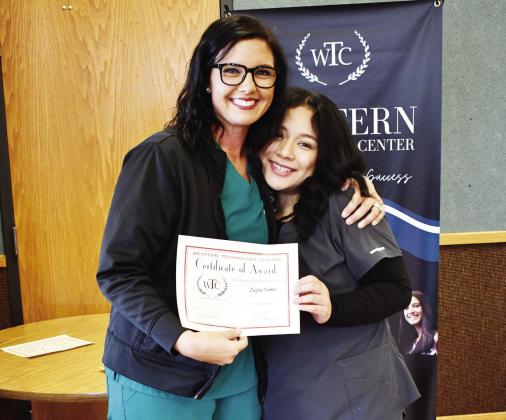 Health careers student Zayra Torres, right, from Clinton High School, receives the Outstanding Student of the Year Award from WTC instructor Kylee Chapman.