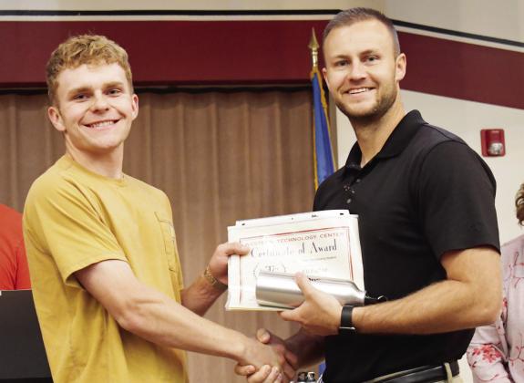 Construction trades student Eli Fuller, left, from Arapaho-Bulter High School, receives the Outstanding Attitude of the Year Award from WTC Director of Student Services Zane Trammell.