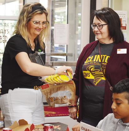 Dandi Gilchrist, left, with Farm Credit of Western Oklahoma, and Washington Elementary Counselor Lana Nix pass out cookies to students, including Alexander Juarez Lopez, selected by their teachers as hardworking Friday afternoon at Washington Elementary S