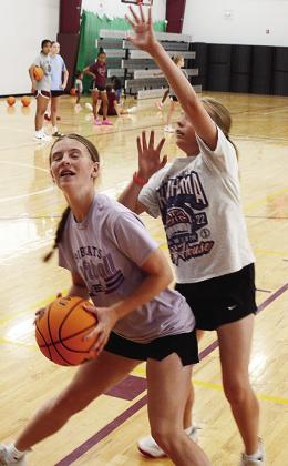 Rennie Kaney, left, tries to drive to the basket while Emmylou Winters guards her during a basketball camp in the practice gym. CDN | Sam Goodwyn