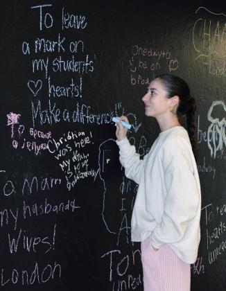 Miranda McLean adds positive notes to the wall of “The Spark Project” space on the corner of Frisco and Sixth Street. CDN | Christian Jacobsen