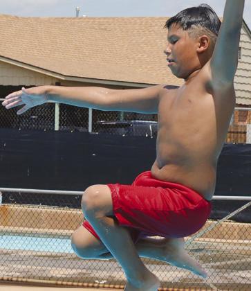 Charlie Moss springs off the diving board at the Clinton Public Pool.