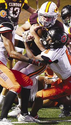 Clinton’s Benton Bridgeman fights through a tackle during the Red Tornadoes’
