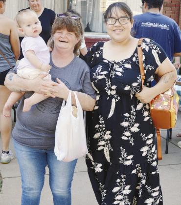 Avery Turner held by Stacy Wilson and Ambria Turner visit the Farmers Market.