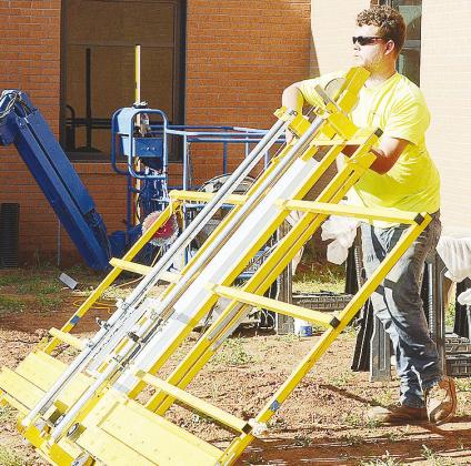 Nick Barnett sets up the saw as he prepares to cut siding for the new Clinton Middle School building. CDN | Sam Goodwyn