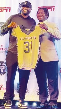 Clinton’s Zaedon Collins, right, accepts his game jersey from NFL vet Victor Butler, who also served as Collins’ defensive coordinator, prior to the All-Star Game. CDN | Courtesy photo